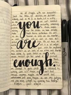 an open notebook with the words you are enough written in cursive writing