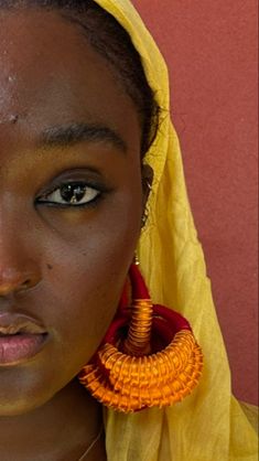 a woman with yellow scarf and earrings on her head