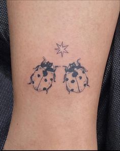 a ladybug tattoo on the side of a woman's leg with a star above it