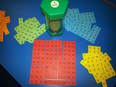 a game with numbers and dices on a blue table next to yellow and orange squares