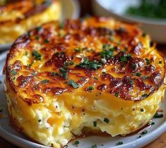 a cheesy casserole on a plate with another dish in the background