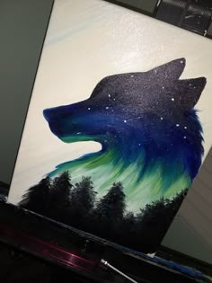 an acrylic painting of a wolf's head with green and blue colors