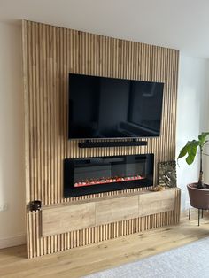 a flat screen tv mounted to the side of a wall next to a fire place