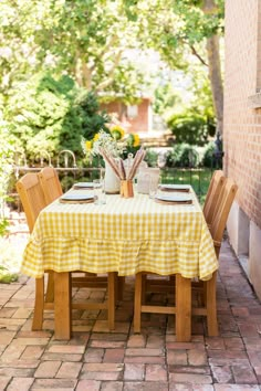 the table is set with yellow and white checkered cloth