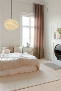 a bedroom with a bed, fireplace and window