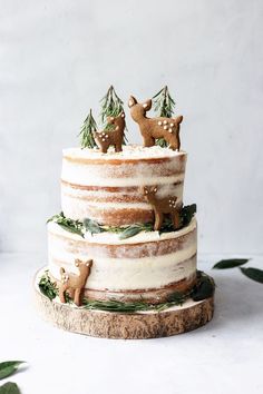 a three tiered cake decorated with deer and pine trees is on the instagram page