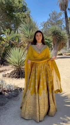 a woman wearing a yellow dress standing in the desert