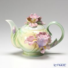 a tea pot with flowers painted on it