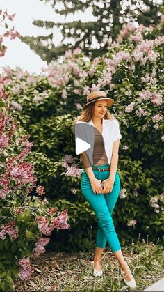 a woman sitting on a bench in front of flowers