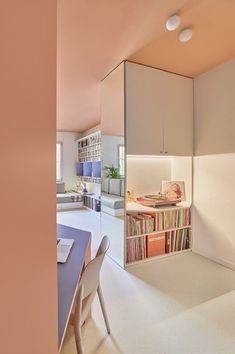 a room with a table, bookshelf and some shelves in the corner next to it