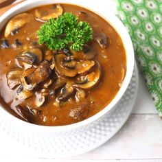 a white bowl filled with mushroom soup and garnished with parsley