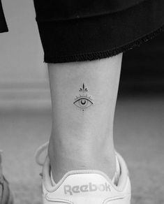 a woman's foot with an eye tattoo on it