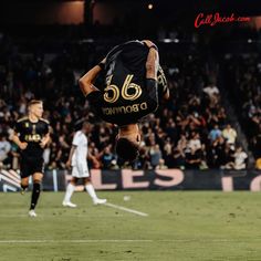 a soccer player is doing a flip in the air with his feet on the ground