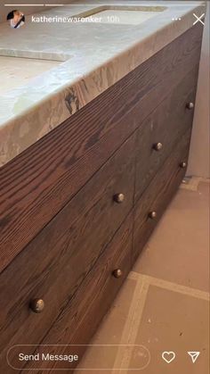 a large wooden dresser with drawers and knobs on the bottom, next to a tile floor