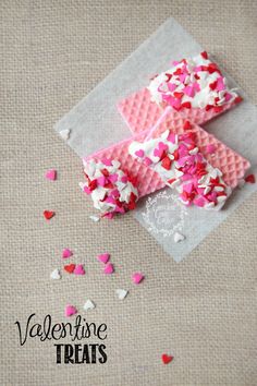 valentine's day treats with pink and red sprinkles on top of a piece of paper