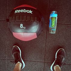 a person standing next to a gym ball and water bottle