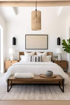 a bed with white sheets and pillows in a bedroom