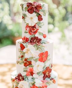 a wedding cake with red and white flowers on it