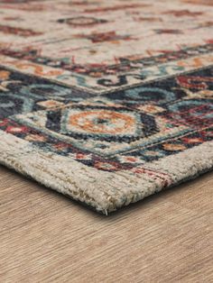 an area rug on top of a wooden floor with a brown and blue color scheme