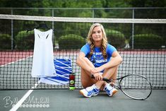 a woman is sitting on the tennis court with her racket and t - shirt