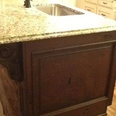 a kitchen with an island in the middle of it and marble counter tops on both sides