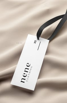 a name tag hanging from the side of a black ribbon on top of a bed