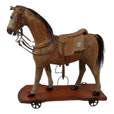 a toy horse is standing on a wooden base