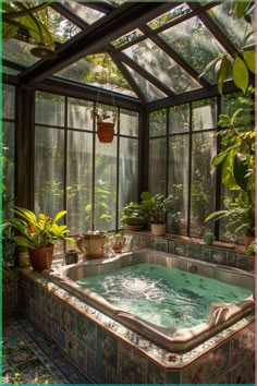 an indoor hot tub surrounded by plants in a room with glass walls and ceilinging