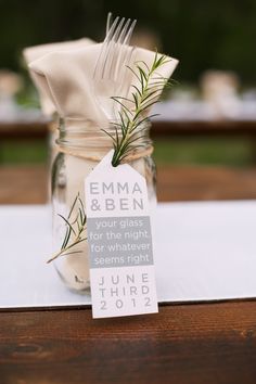 a mason jar filled with forks and napkins on top of a table