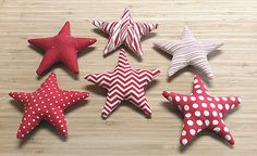 five red and white stars are arranged on a wooden surface with polka dot dots in the center