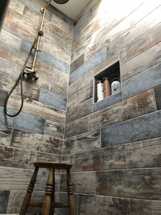 a shower with wood tile and a wooden stool