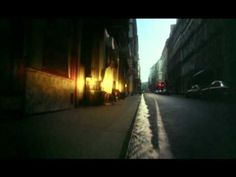 an empty city street at night with the sun shining down on it's buildings