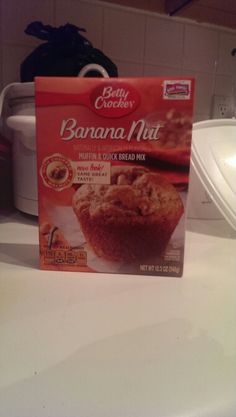 a box of banana nut muffins sitting on top of a counter next to a microwave