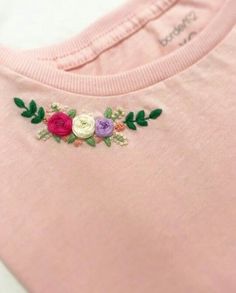 a pink t - shirt with flowers embroidered on it