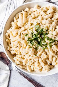 a bowl filled with macaroni and cheese on top of a white table cloth