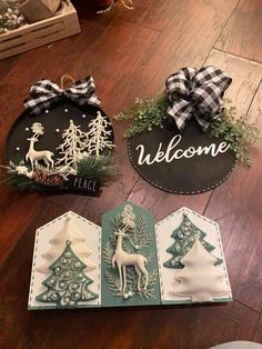 three christmas decorations are sitting on the floor next to a welcome sign and other items