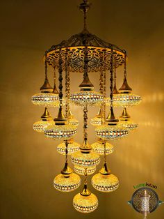 a chandelier hanging from the ceiling in a room with gold walls and flooring