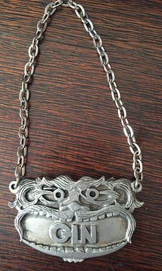 an old silver purse with chains hanging from it's sides on a wooden table