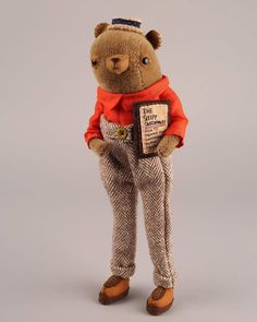 a brown teddy bear wearing an orange shirt and pants with his hands in his pockets