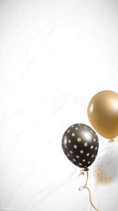 two black and gold balloons sitting on top of a white marble countertop next to each other