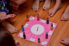 several children standing around a pink board with different nail polishes on it and a clock