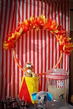 there is a stuffed elephant and other items on the table in front of a circus tent