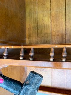 a person holding a hammer in front of a wooden shelf with many knobs on it