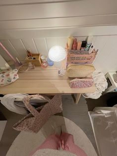 a table with many items on it in a room that is white and has wood flooring