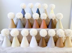 a bunch of different colored cones with pom - poms on them