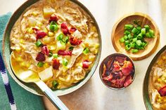 two bowls filled with food on top of a table next to wooden spoons and green onions