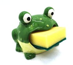 a green frog sitting on top of a yellow sponge