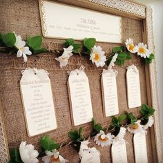 a bulletin board decorated with flowers and place cards for guests to write their names on