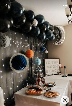 a party table with balloons and food on it