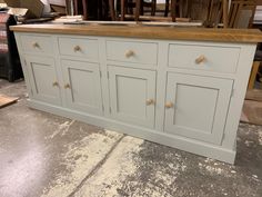 a kitchen island made out of wood and painted in light blue with gold knobs